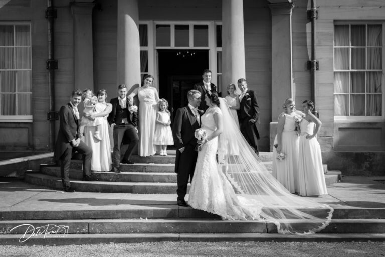 Bride and groom posing with bridesmaids, best man and ushers on the steps of Saltmarshe Hall.