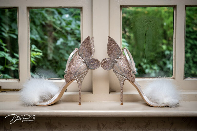 Designer wedding shoes with large butterfly wings attached to the back.