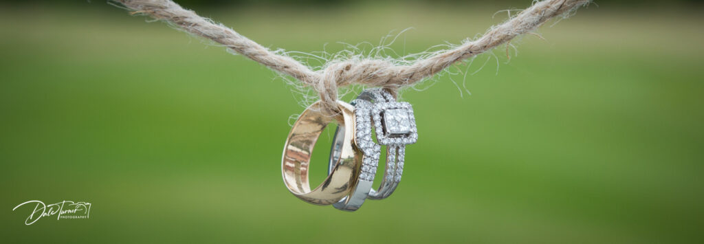 Wedding rings tied together with frayed string.