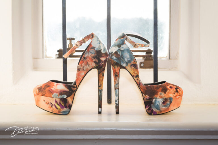 Designer wedding shoes on a windowsill.