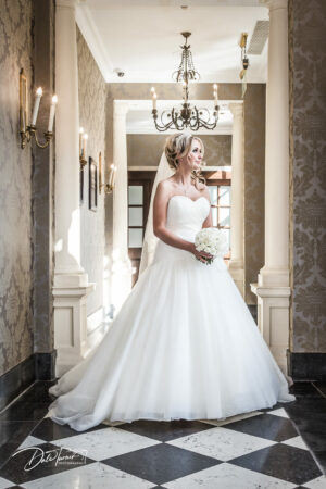 Bride standing alone inside Oulton Hall.