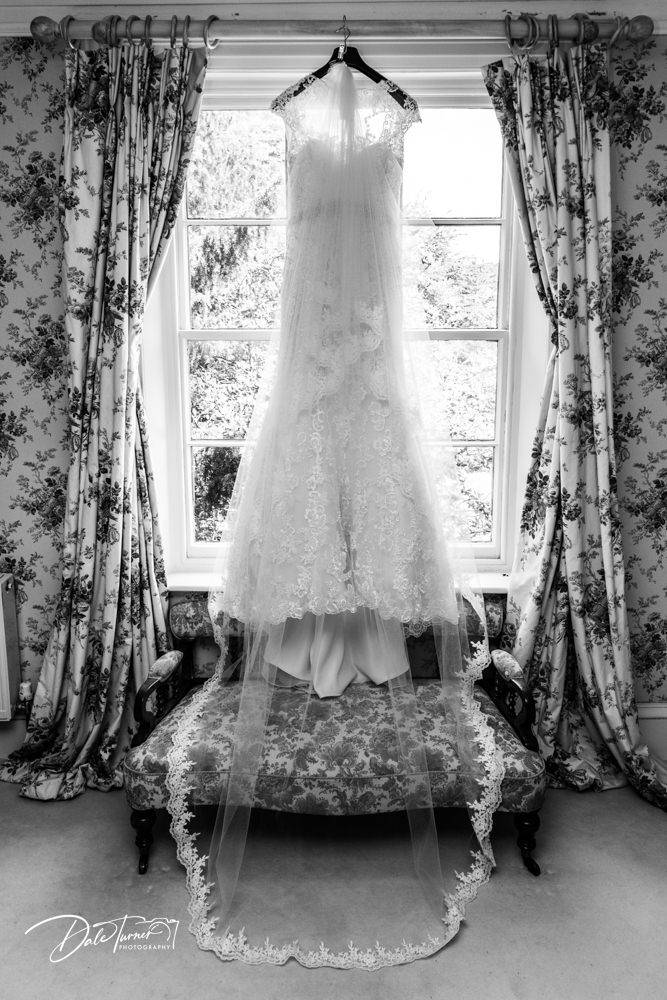 Wedding dress hung in the window in the bridal suite at Saltmarshe Hall.