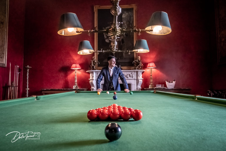 Groom leaning on a snooker table, at Allerton Castle.