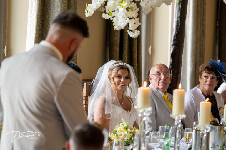 Best Man delivering his speech and the bride is looking at him and smiling. At Carlton Towers.