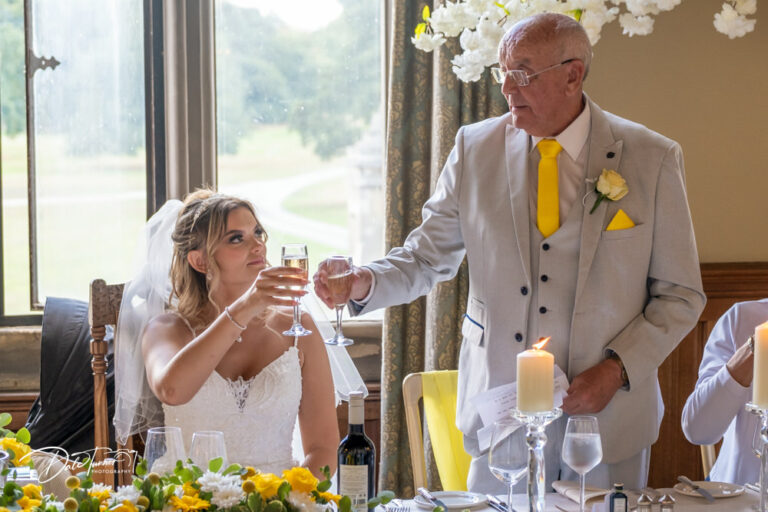 Father of the bride and the bride toasting glasses after a speech at Carlton Towers.