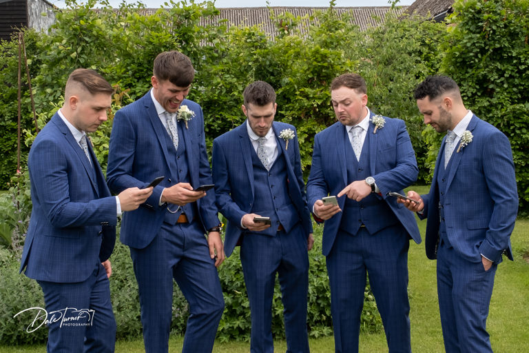 Groom and groomsmen on their phones.