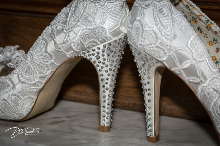 Close up of diamantés attached to the stiletto heels of a pair of wedding shoes.