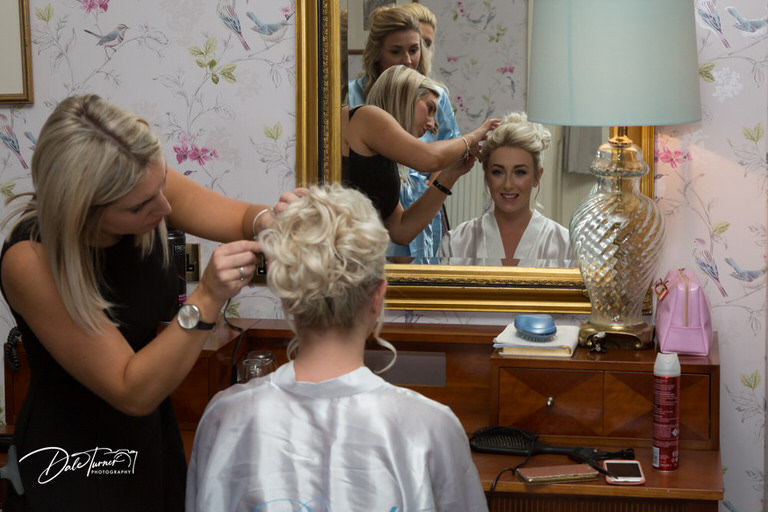 A bride having her hair styled.