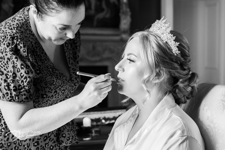 Bride having lipstick applied, at Allerton Castle.