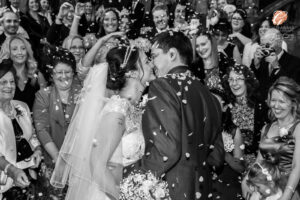 Award winning photograph of a bride and groom kissing with confetti being thrown over them at Carlton Towers.