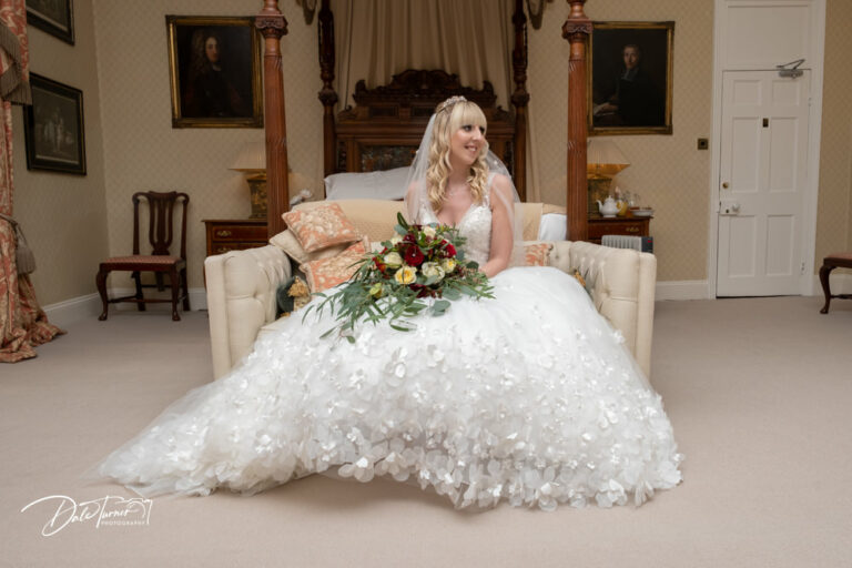 Bride sat on a couch in the bridal suite of Carlton Towers.