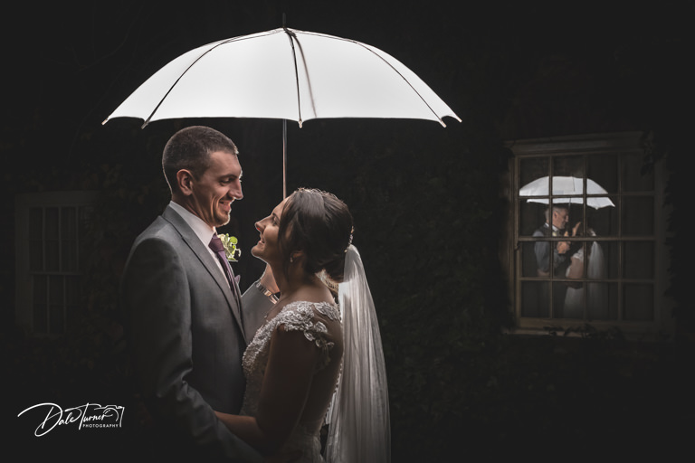 Bride and groom with white umbrella at night, at The York Pavilion Hotel.