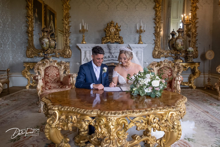 Bride and groom signing the wedding register, at Allerton Castle.