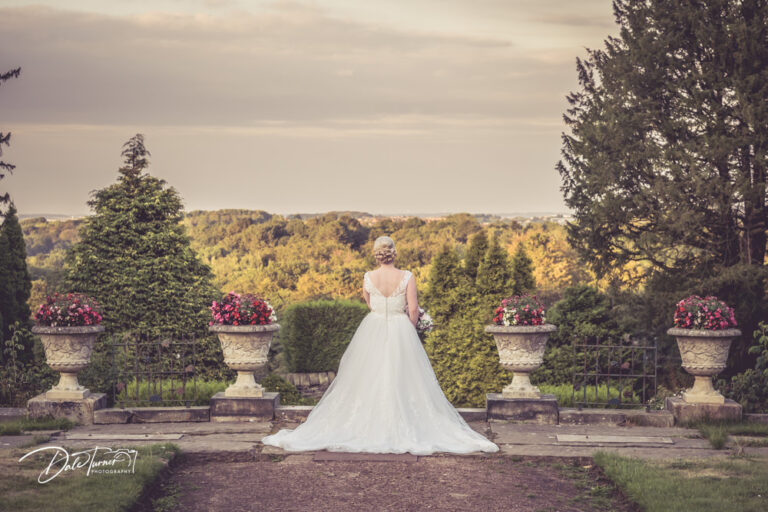 Bride from behind, looking out over the trees at Wortley Hall.