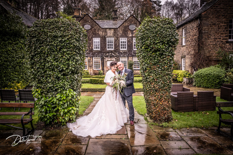 Bride and groom outside in the rain at Whitley Hall.