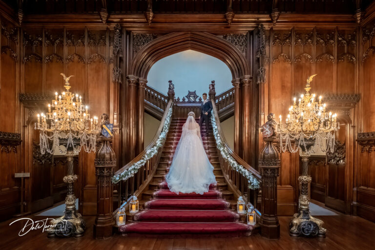 Bride and groom posing on the stair case inside Allerton Castle.