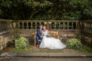 Bride and groom sat on a bench at Wortley Hall, Barnsley.