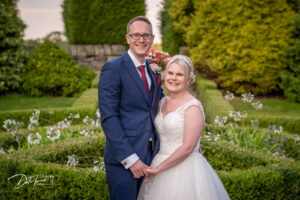 Bride and groom holding hands and smiling in the grounds of Wortley Hall, Barnsley.