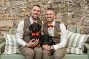 Two grooms with their dachshund dog, all wearing bow ties. At Loversall Farm, Tickhill.