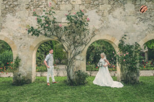 Award winning photograph of a bride and groom standing under arches and looking at each other. At Chateau Sentout, Bordeaux, France.