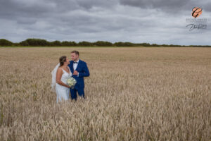 Award winning photograph of a bride and groom standing in a corn field.