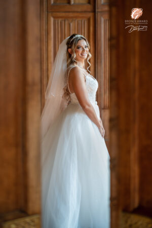 Award winning photograph of a bride through a gap in large wooden doors, at Carlton Towers.