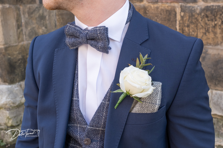 Man in suit with bow tie and buttonhole.