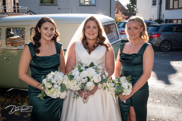 Bride and bridesmaids with bouquets and vintage VW Camper van.