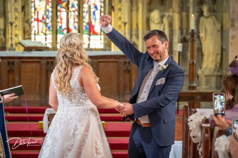 Groom punching the air after wedding ceremony at Howden Minster.