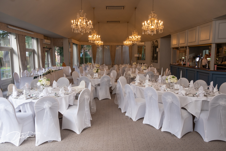 An elegant wedding reception room is set up with chandeliers at The Parsonage.