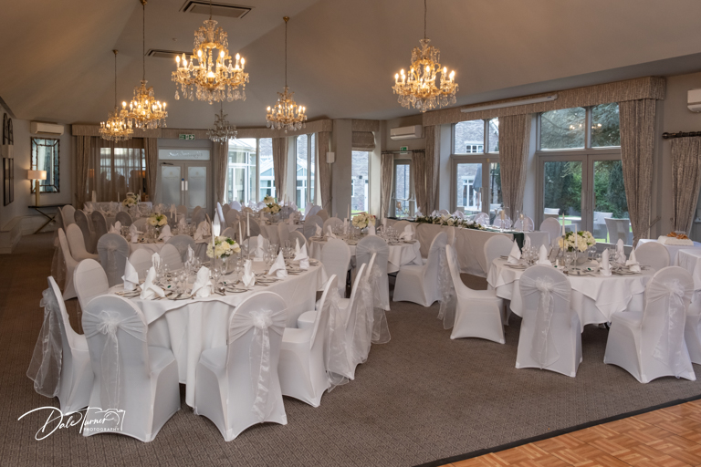 Elegant wedding venue interior with chandeliers and set tables at The Parsonage.