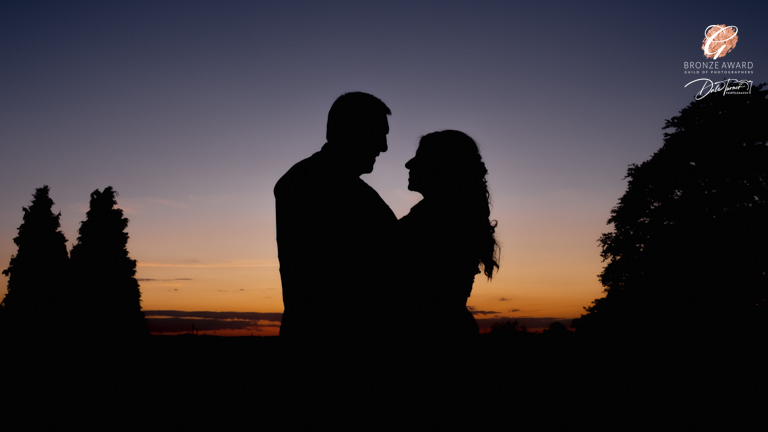 Couple silhouette at sunset, romantic wedding photo.