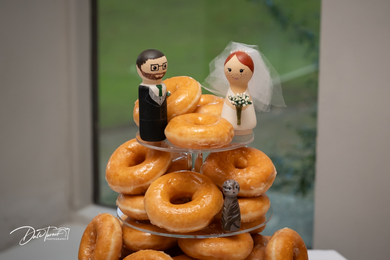 Wedding cake topper on a doughnut tower.