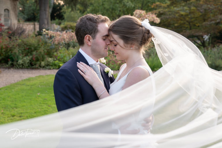 Bride and groom sharing a tender moment in a garden setting