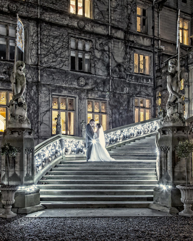 Couple kissing on illuminated stairs of grand building