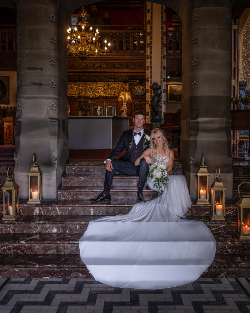 Wedding couple seated on ornate stairway with lanterns