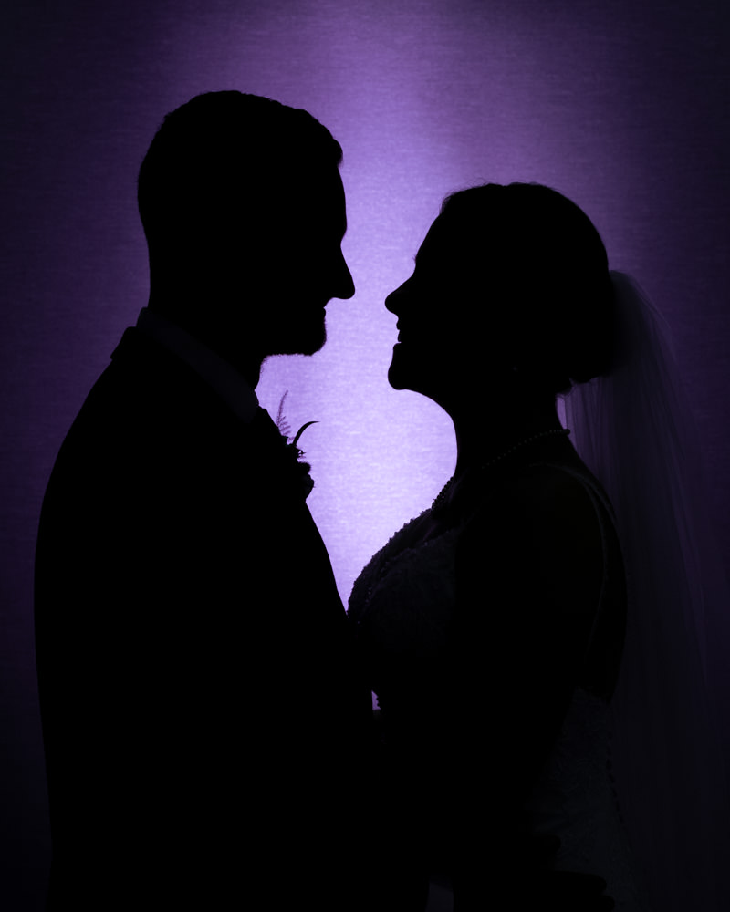 Silhouette of couple facing each other with purple backlight