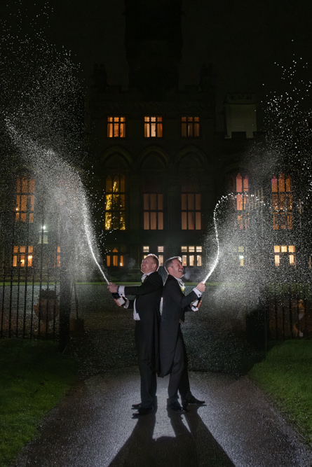 Men spraying champagne outside Carlton Towers at night